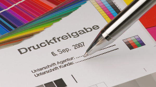 Druckfreigabeformular mit Farbmuster und Kugelschreiber.